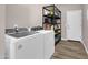 Functional laundry room with a full-size washer and dryer and ample storage shelving at 19711 W Colter St, Litchfield Park, AZ 85340