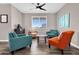Modern living room with hardwood floors, bright accent chairs, and a ceiling fan at 19711 W Colter St, Litchfield Park, AZ 85340