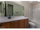 Modern bathroom with a wooden vanity cabinet, white countertop, and combined shower and tub at 20128 W Jackson St, Buckeye, AZ 85326