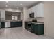 Stylish kitchen with white and green cabinets, stainless steel appliances, and tile flooring, offering a sleek design at 20128 W Jackson St, Buckeye, AZ 85326