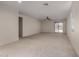 Bright living room with neutral carpet, ceiling fan, recessed lighting, and sliding glass door to the backyard at 20128 W Jackson St, Buckeye, AZ 85326