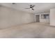 Bright living room with neutral carpet, ceiling fan, recessed lighting, and large windows at 20128 W Jackson St, Buckeye, AZ 85326