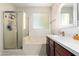 Well-lit bathroom with a glass door shower, bathtub, and vanity with granite countertop at 205 N 107Th Dr, Avondale, AZ 85323