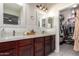 A dual sink bathroom vanity with framed mirrors, tile backsplash, and access to a closet at 205 N 107Th Dr, Avondale, AZ 85323