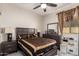 Bedroom featuring a dark wood bed set, tile floors, and natural light at 205 N 107Th Dr, Avondale, AZ 85323