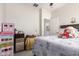 Bedroom features tile floors, a cozy bed, and an open closet door to laundry room at 205 N 107Th Dr, Avondale, AZ 85323