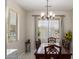 Inviting dining room features a modern chandelier and a large window at 205 N 107Th Dr, Avondale, AZ 85323