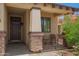 Inviting front porch with stone accents, seating area, and desert landscaping at 205 N 107Th Dr, Avondale, AZ 85323