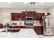 A well-equipped kitchen featuring stainless steel appliances, white subway tile backsplash, and stylish wood cabinets at 205 N 107Th Dr, Avondale, AZ 85323