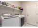 Laundry room with side-by-side machines and shelf storage above at 205 N 107Th Dr, Avondale, AZ 85323