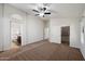Spacious main bedroom with carpet flooring, ceiling fan, and access to the bathroom at 20814 N Dries Rd, Maricopa, AZ 85138