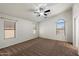 Sunlit main bedroom with plush carpeting, large windows, and a ceiling fan at 20814 N Dries Rd, Maricopa, AZ 85138