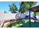 A view of the backyard with a block wall and a section of artificial turf lawn, and a covered patio at 2416 W Caribbean Ln # 2, Phoenix, AZ 85023