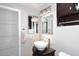 Bathroom with a modern vessel sink on a black vanity, decorative mirrors, vanity lighting, and a two-door closet at 2416 W Caribbean Ln # 2, Phoenix, AZ 85023