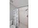 Bathroom with a tiled shower, mosaic tile floors, a toilet, white wall tiles, and a blue and white map shower curtain at 2416 W Caribbean Ln # 2, Phoenix, AZ 85023