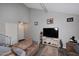 Bright living area featuring a cozy sofa, tv, and easy access to stairs and front door at 2416 W Caribbean Ln # 2, Phoenix, AZ 85023