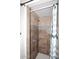 Shower with tan tile, a shower head, a white ceiling, mosaic tiles, and a patterned blue and white shower curtain at 2416 W Caribbean Ln # 2, Phoenix, AZ 85023