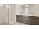 Modern bathroom featuring a glass-enclosed shower, dual vanity sinks, and a large mirror at 25347 N 176Th Ave, Surprise, AZ 85387