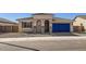 Charming single-story home featuring a tiled roof, blue garage door, and landscaped front yard at 25347 N 176Th Ave, Surprise, AZ 85387