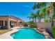 Inviting pool with rock feature, swaying palm trees, and a cozy lounge area in a private backyard at 26072 N 74Th Ave, Peoria, AZ 85383