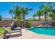 Inviting pool with rock feature, swaying palm trees, and a cozy lounge area in a private backyard at 26072 N 74Th Ave, Peoria, AZ 85383