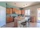 A kitchen features a central island, wood cabinetry, stainless steel appliances and tile flooring at 26072 N 74Th Ave, Peoria, AZ 85383