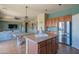Open kitchen with stainless appliances, kitchen island with barstool seating and view to the living room at 26072 N 74Th Ave, Peoria, AZ 85383