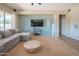Stylish living room featuring a sectional sofa, entertainment center, and accent wall at 26072 N 74Th Ave, Peoria, AZ 85383