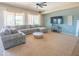 Comfortable living room with a large sectional sofa, modern ceiling fan, and entertainment setup at 26072 N 74Th Ave, Peoria, AZ 85383