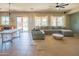 Spacious living room with a large sectional sofa, ceiling fan, and sliding glass doors to the backyard at 26072 N 74Th Ave, Peoria, AZ 85383