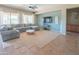 Bright living room features a large sectional, ceiling fan, and view of the outdoor space at 26072 N 74Th Ave, Peoria, AZ 85383