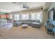 Open-concept living room with a large sectional sofa, kitchen view, and plenty of natural light at 26072 N 74Th Ave, Peoria, AZ 85383