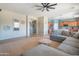 Beautiful living room with a large sectional, open floor plan, and view into the adjacent kitchen area at 26072 N 74Th Ave, Peoria, AZ 85383