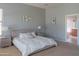 Bright main bedroom with a neutral palette, decorative wall art, and an ensuite bathroom for added convenience at 26072 N 74Th Ave, Peoria, AZ 85383