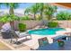 Private backyard oasis with freeform pool, rock waterfall, lounge chairs, and dining area at 26072 N 74Th Ave, Peoria, AZ 85383