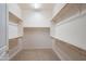 Expansive walk-in closet featuring wooden rods and shelving, providing a well-organized storage solution at 26072 N 74Th Ave, Peoria, AZ 85383