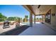 Expansive backyard with covered patio, outdoor seating, decorative fire pit, and swimming pool with waterfall feature at 26135 N Desert Mesa Dr, Surprise, AZ 85387
