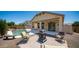 Relaxing backyard with a cozy seating area, brick-paved fire pit, a covered patio and refreshing pool at 26135 N Desert Mesa Dr, Surprise, AZ 85387