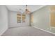 Bedroom featuring bright windows, soft neutral colors, carpeted floors, and a decorative light fixture at 26135 N Desert Mesa Dr, Surprise, AZ 85387