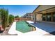 Sparkling pool with waterfall feature, surrounded by a spacious patio, lush landscaping and a covered area at 26135 N Desert Mesa Dr, Surprise, AZ 85387