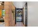 Hallway with brick accent wall and access to an outdoor area at 3032 N 32Nd St # 61, Phoenix, AZ 85018