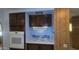 A kitchen featuring dark wood cabinets, a built-in oven, and blue decorative tiling at 3104 E Broadway Rd # 268, Mesa, AZ 85204