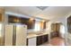Well-lit kitchen with white appliances, dark cabinets, and an arched doorway at 3104 E Broadway Rd # 268, Mesa, AZ 85204