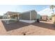 Exterior view featuring covered patio, gray siding, white skirting, and central air conditioning unit at 320 E Mckellips Rd # 25, Mesa, AZ 85201