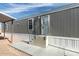 Gray home exterior with white trim, featuring a covered carport and landscaped yard at 320 E Mckellips Rd # 25, Mesa, AZ 85201