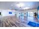 A modern recreation room with a high ceiling, ceramic wood-look tile flooring, and large windows to the pool area at 320 E Mckellips Rd # 25, Mesa, AZ 85201