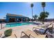 A beautiful community pool area with lounge chairs, palm trees, and a covered patio area for relaxing in the shade at 320 E Mckellips Rd # 25, Mesa, AZ 85201