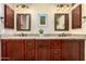 Bathroom features double sink vanity, wood cabinetry, granite counters, framed mirrors, and updated fixtures at 3535 E Brookwood Ct, Phoenix, AZ 85048