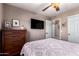Cozy bedroom features a TV, ceiling fan, dresser and light gray bedding at 3535 E Brookwood Ct, Phoenix, AZ 85048