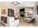 Bright living room features fireplace, ceiling fan, tile flooring, and comfortable furniture at 3535 E Brookwood Ct, Phoenix, AZ 85048